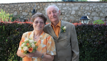 Photo of an elderly couple in front of a stonewall Photo of an elderly couple in front of a stonewall