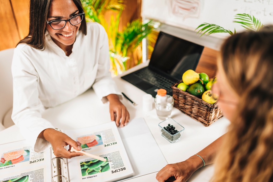 Dietitian smiling and showing patient some health information