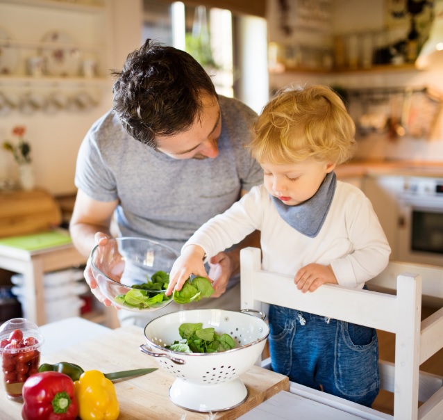 Father and son cooking with spinach 