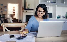 Woman working at kitchen table on laptop