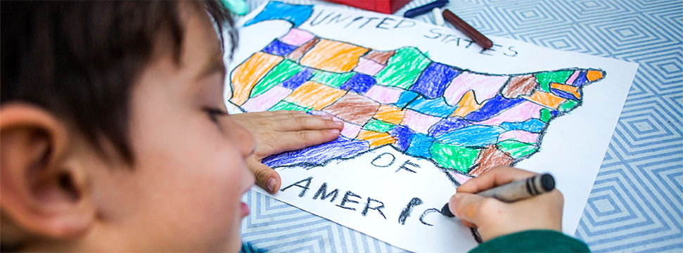 Small boy coloring in a map of the United States