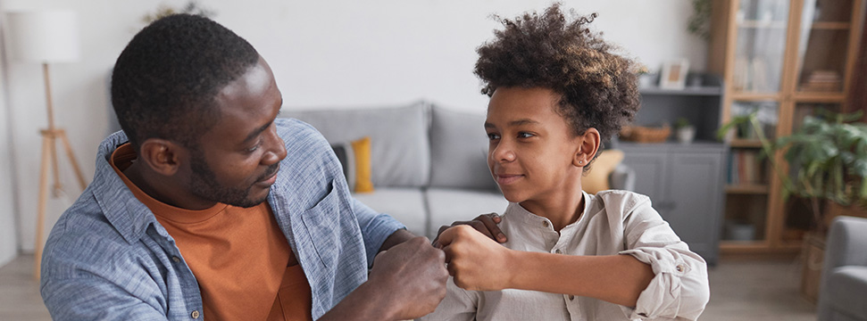 Dad and young son fist bumping and happy