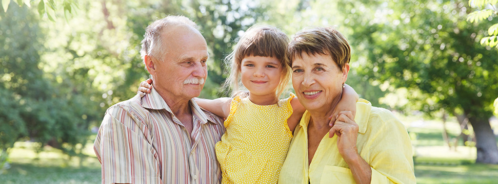 Grandparents holding their young granddaughter 