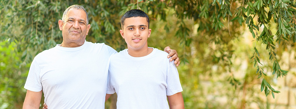 Father and Son posing for the camera while outdoors 