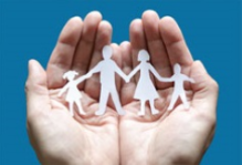 hands holding a paper cutout of a family