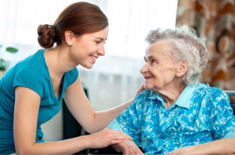 Caregiver assisting an elderly woman.